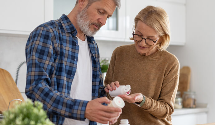An elderly couple checks medicine bottles together, highlighting the importance of medication management in their daily routine.