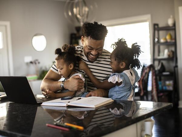 A dad hugging his two children