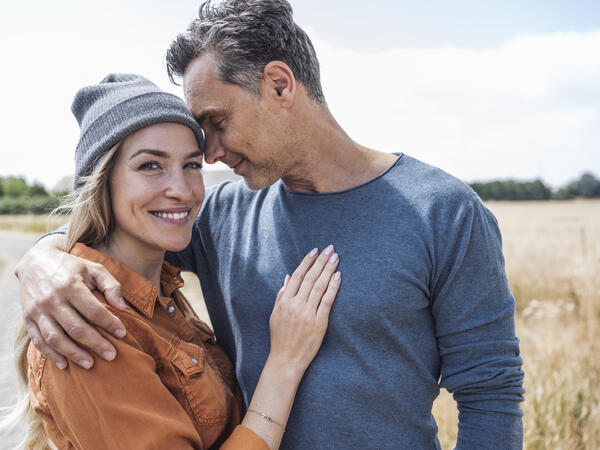 A younger couple smiling while outside