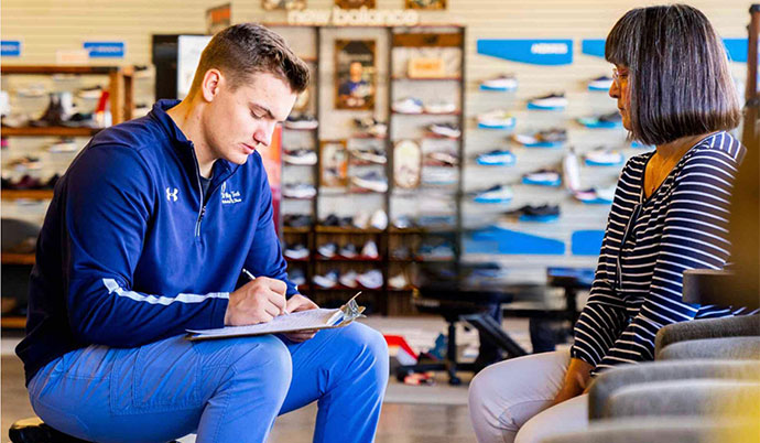 Fit My Feet employee helping customer