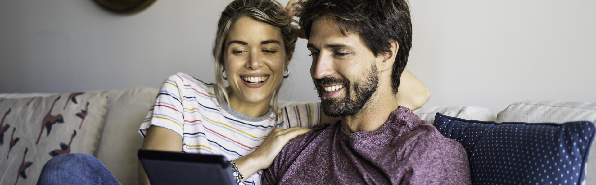 Couple happily looing at a tablet