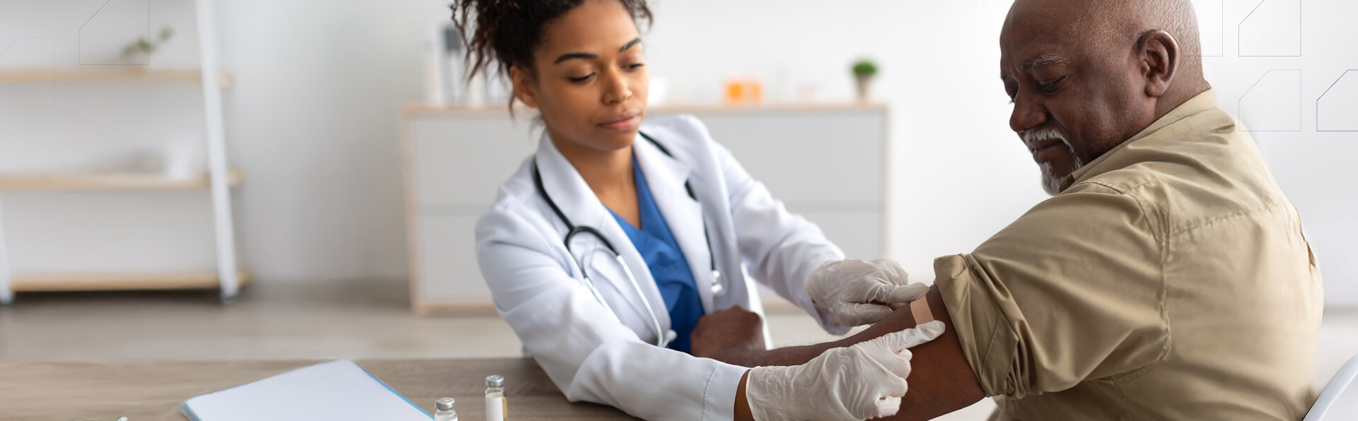 A medical provider who place a bandage on a patient after a vaccine.