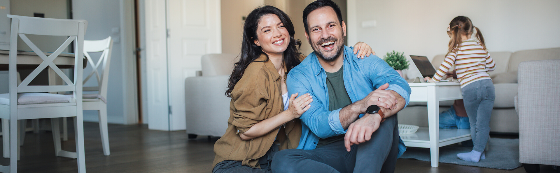 A young family in their home smiling.