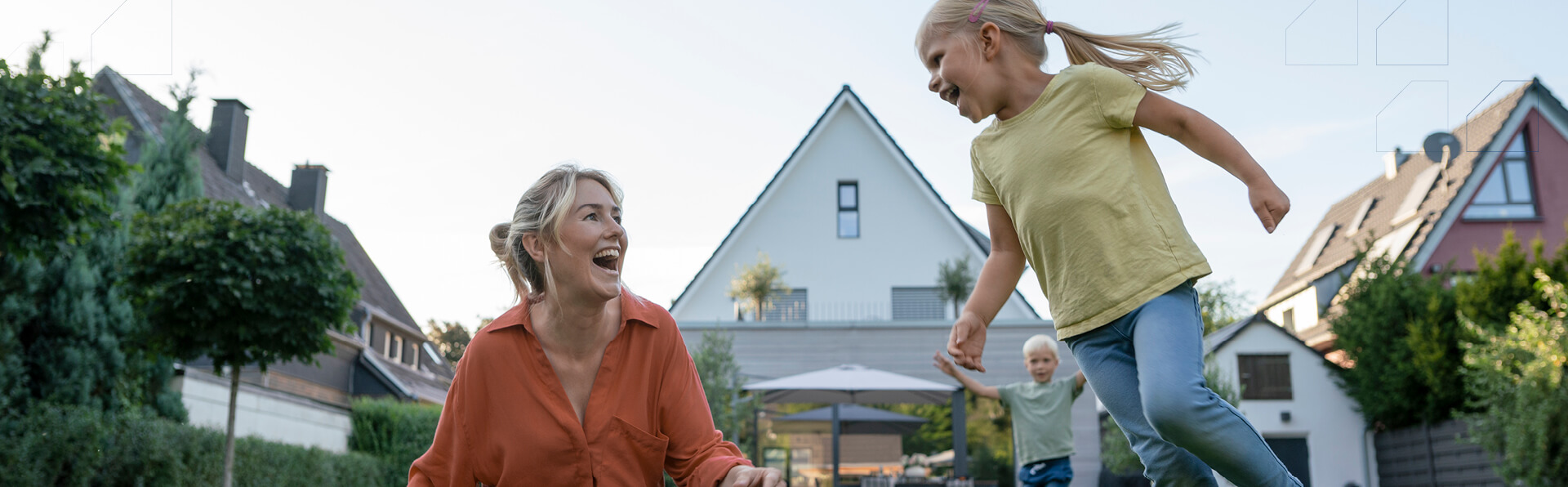 A young child running around outside while her mom is watching.