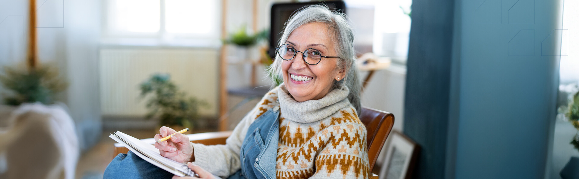A mature older woman in her living room writing in her notebook.