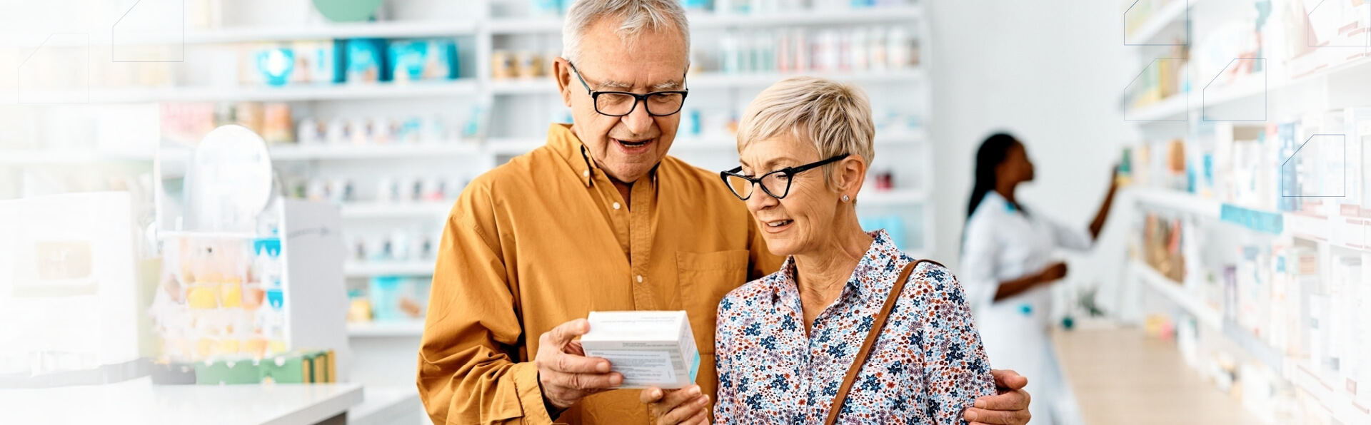 A gray-haired Caucasian couple dressed in bright-colored clothing are reading a product label while a pharmacist restocks shelves in the background