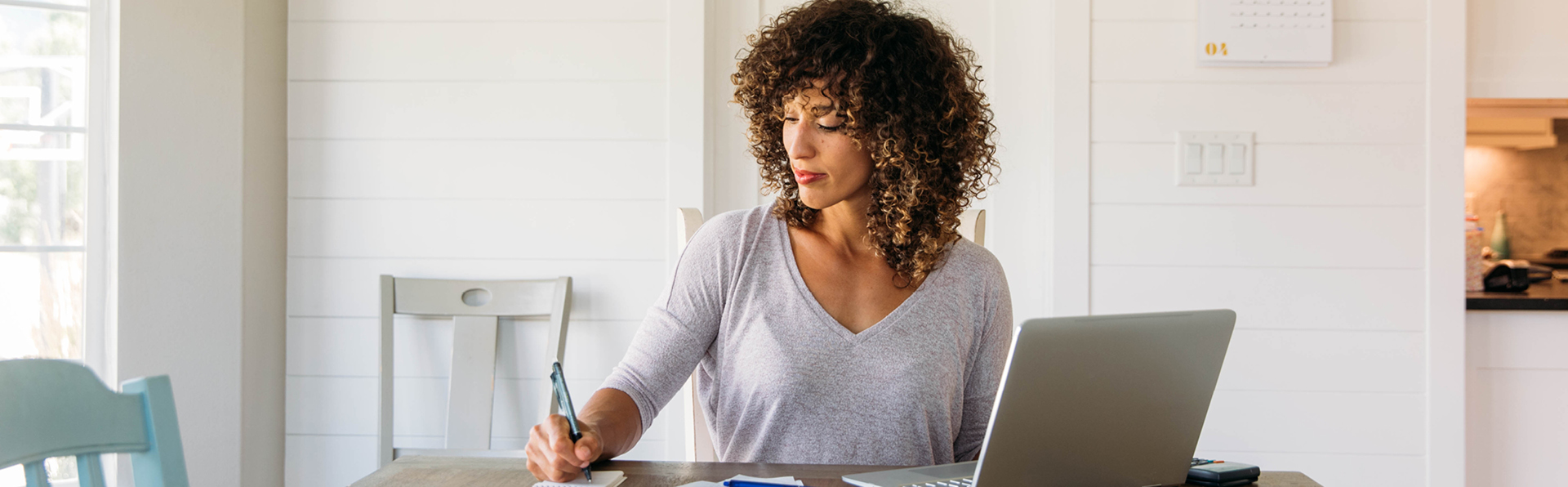 Woman sitting at desk writing notes