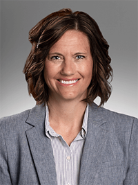Professional head shot image of Jennie Nickles wearing a light gray blouse and a dark gray blazer.